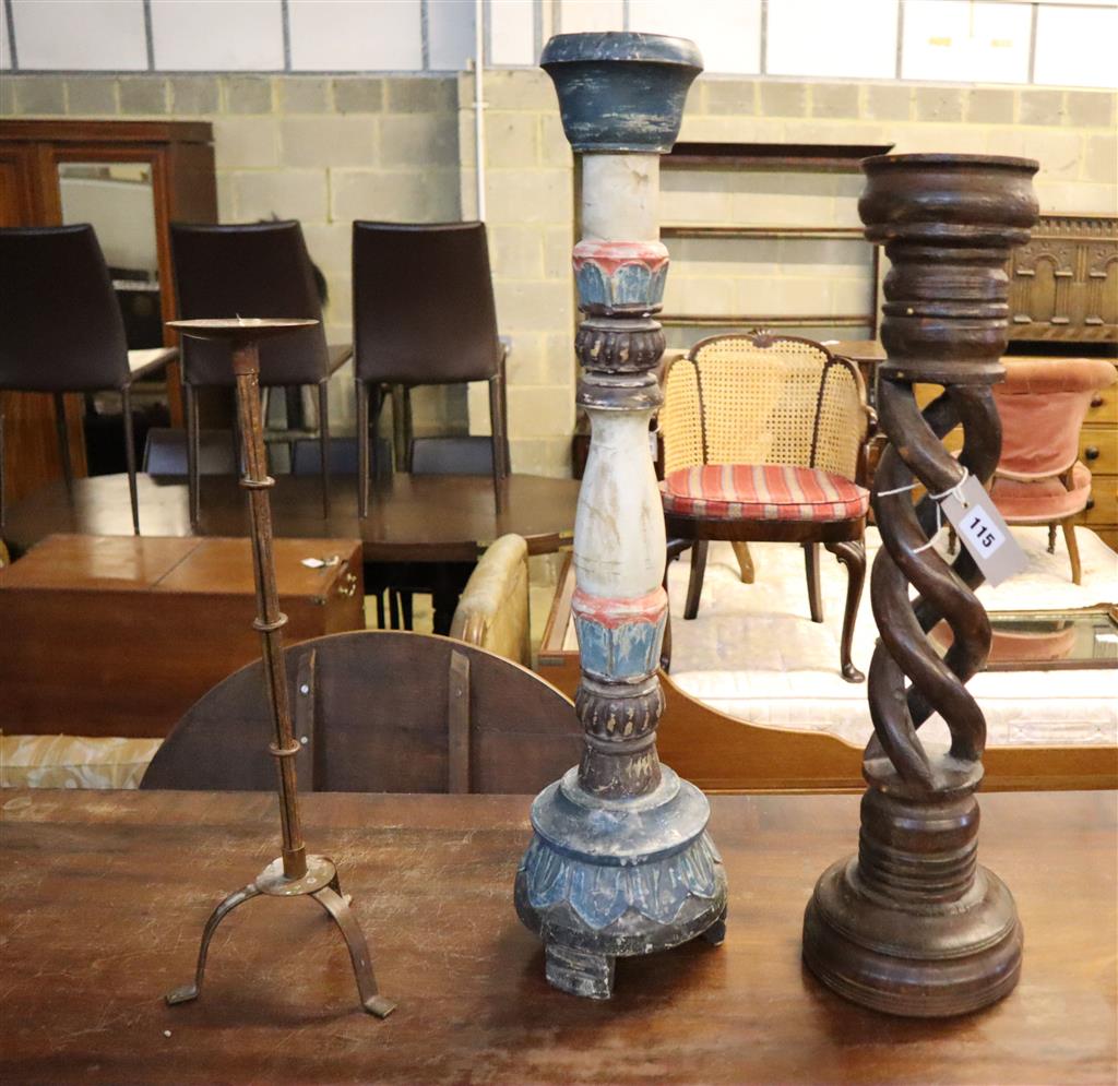Two carved wooden candlesticks and an iron pricket candlestick (3), largest 87cm high
